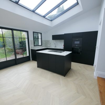 Cuisine noire îlot verrière toit vitré parquet